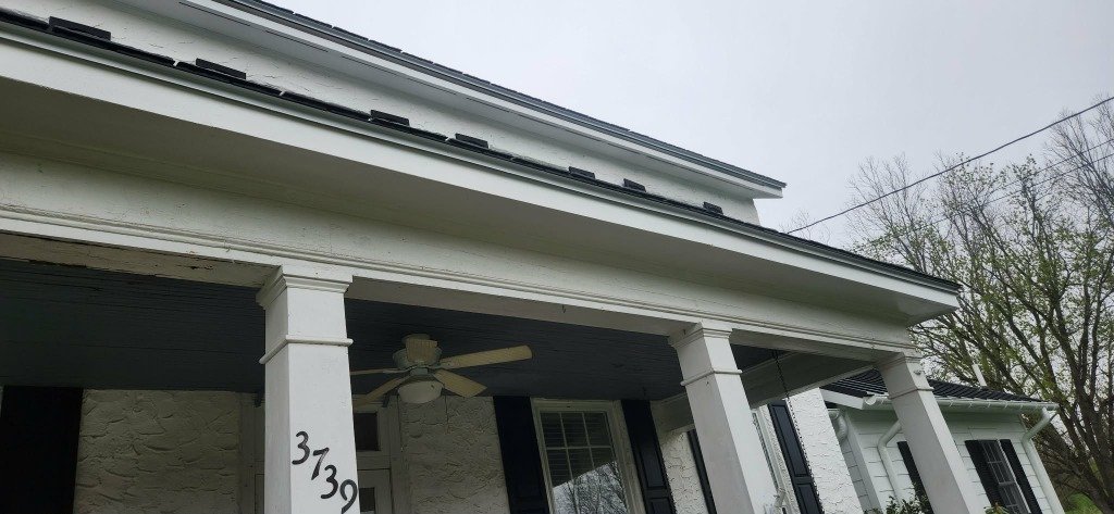 White farmhouse completed gutter installation