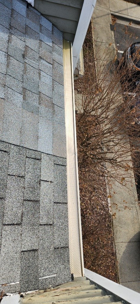 Close-up of perforated gutter guard being installed